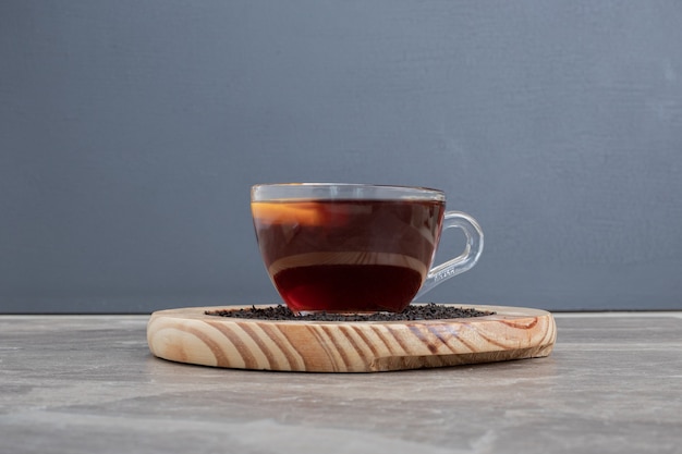 Hot, aroma tea on wooden plate on marble table.