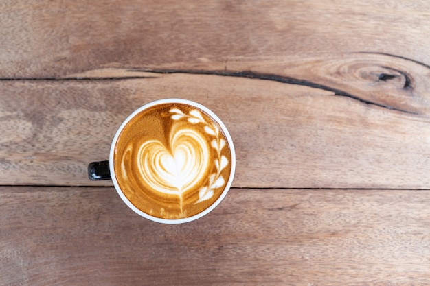 Free photo hot art coffee cappuccino in a cup on wooden table background  with copy space