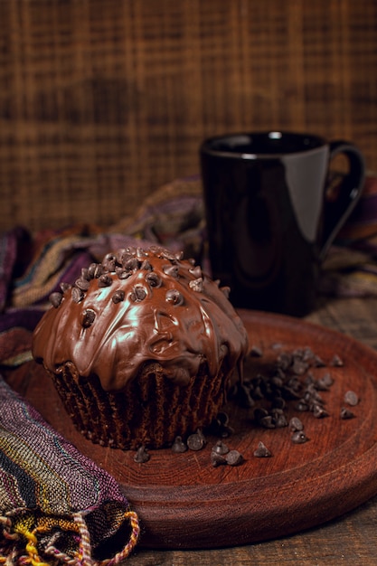 Free photo hot chocolate mug and muffin on wood board