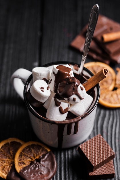 Free photo hot chocolate with marshmallows cinnamon stick and dried orange slices