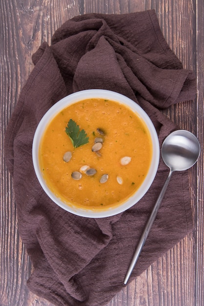 Free photo hot cream soup with spoon on kitchen cloth