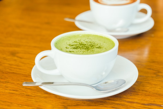 Hot green matcha latte in white cup