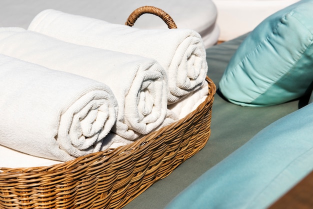 Free Photo hotel towels rolled in wooden basket