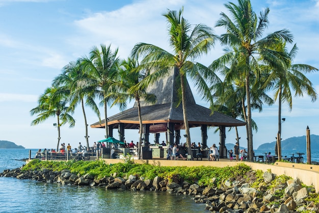 Free photo house between palm trees and sea