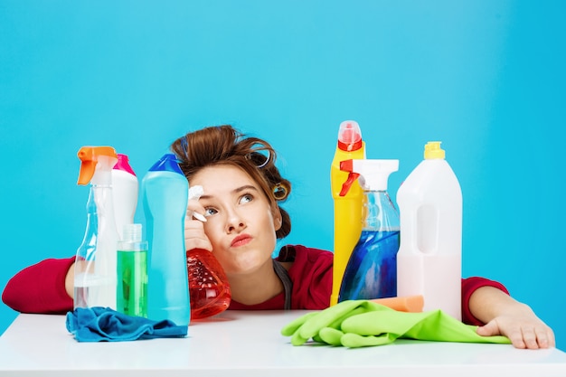 Housewife looks tired and deep in thoughts while cleaning and washing