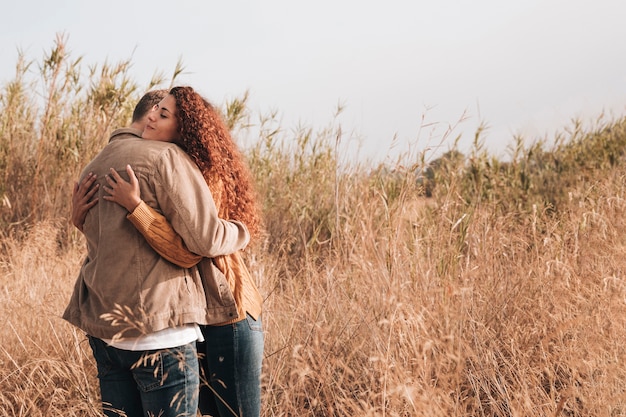 Free photo hugging couple in wheat field