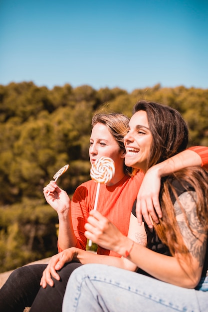 Hugging women with lollipops