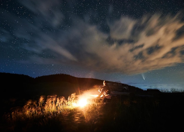 Free photo human enjoying cozy bonfire and beautiful starry sky