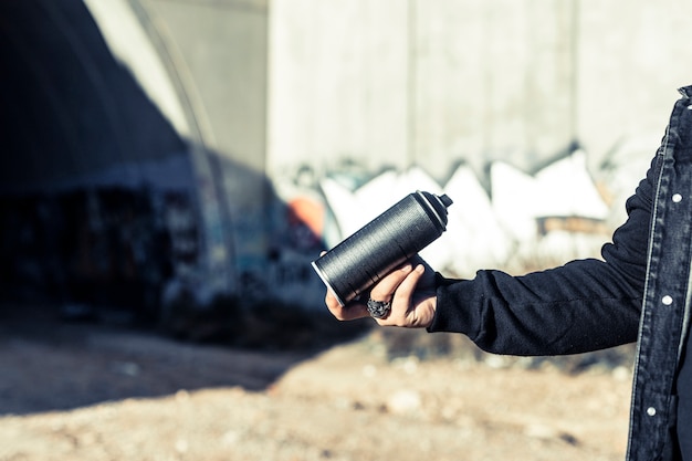 Human hand holding black aerosol can