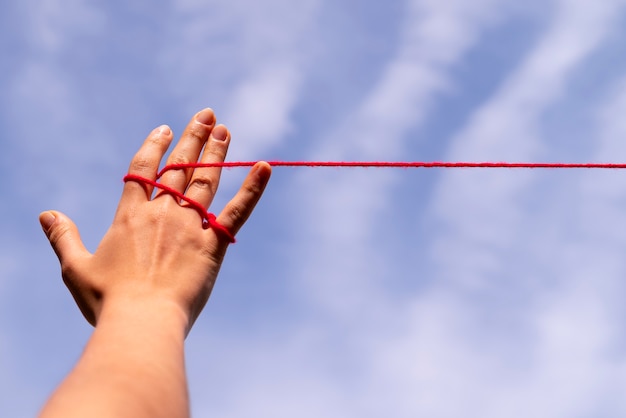 Human hands connected with red thread