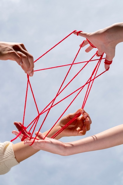 Human hands connected with red thread