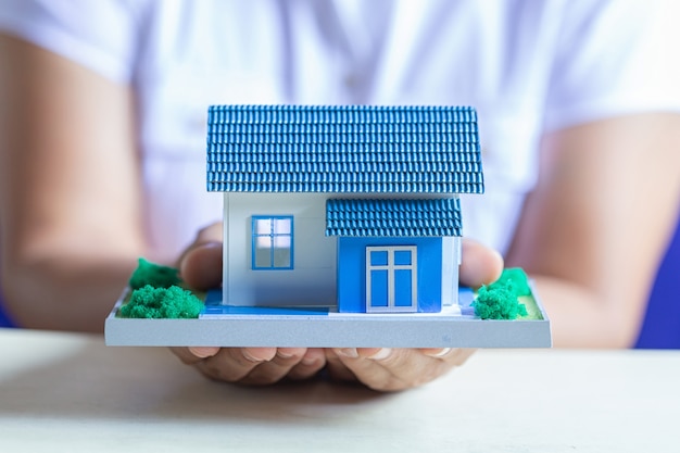 Free photo human hands holding model of dream house