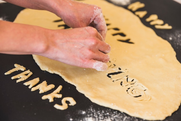 Free photo human hands taking away dough letters