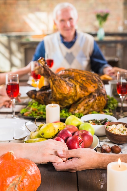 Free Photo human holding hands at table with food near aged man 