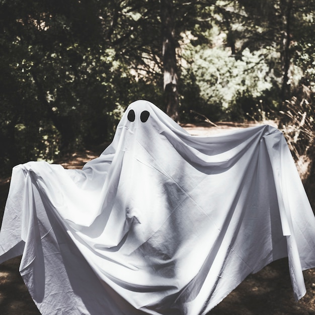 Free photo human in phantom clothes with upping hands in forest