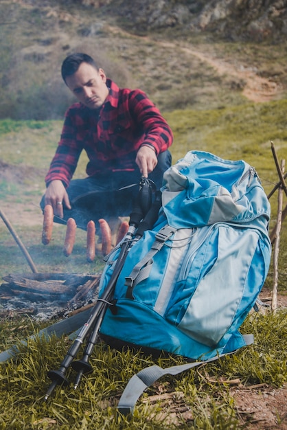 Hungry traveler preparing sausages