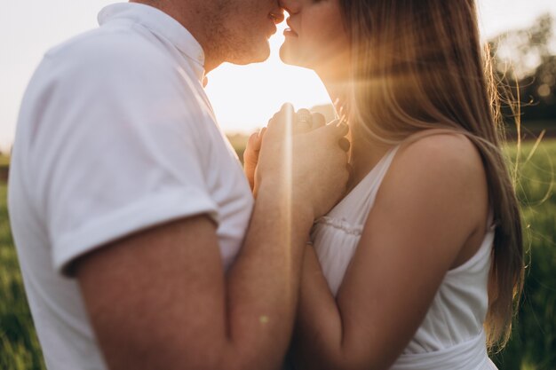 The husband kissing his wife and standing on the field