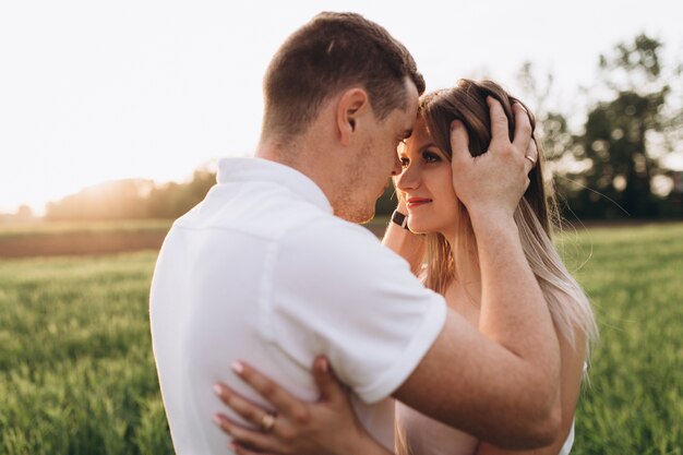 The husband kissing his wife and standing on the field