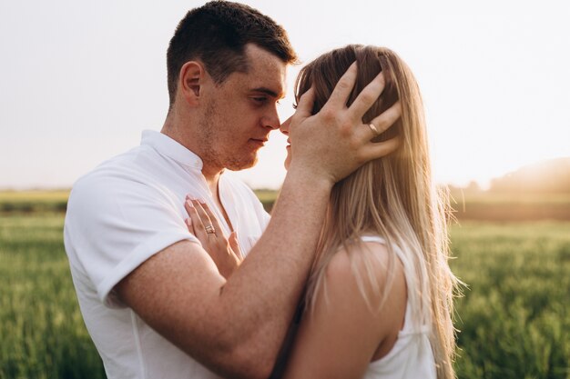 The husband kissing his wife and standing on the field