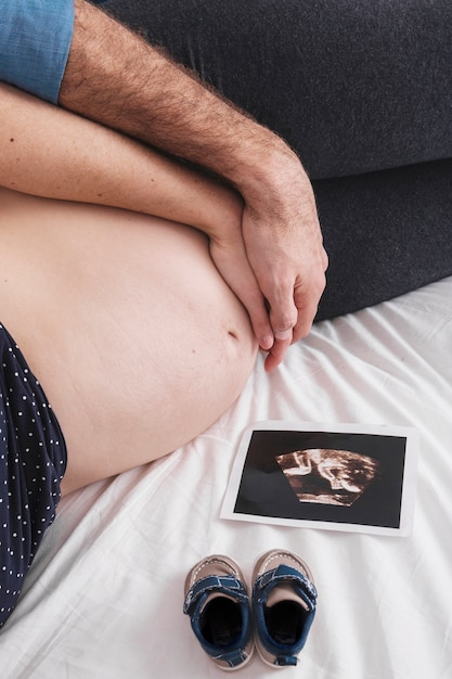 Free photo husband and pregnant woman hugging on bed