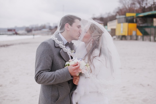 Husband and wife kissing under the veil