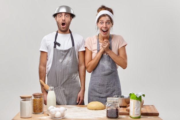 Husband and wife pose in the kitchen preparing tasty dinner