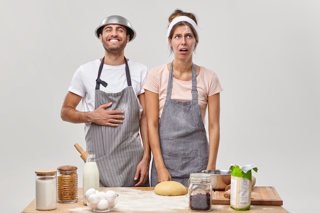 Husband and wife pose in the kitchen preparing tasty dinner