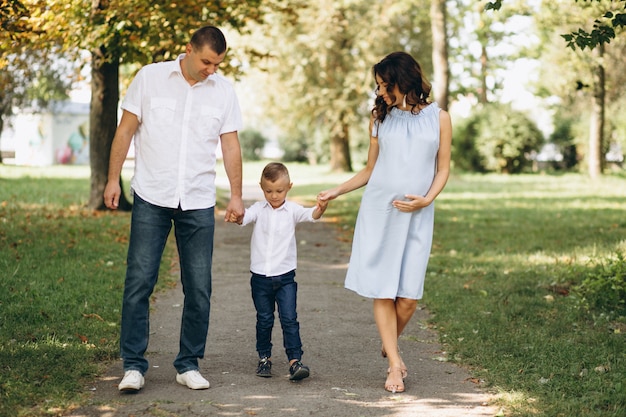 Husband with pregnant wife and their son in park