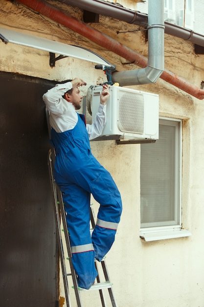 HVAC technician working on a capacitor part for condensing unit