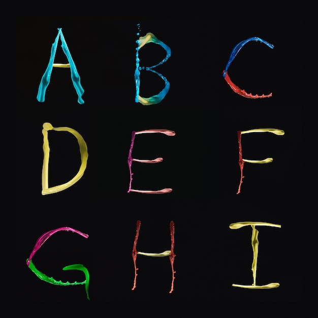 Free Photo a to i alphabets formed by multi colored watercolor on black background