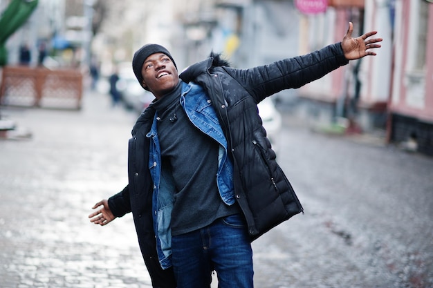 I am so happy African man wear on jacket and black hat at cold weather posed outdoor