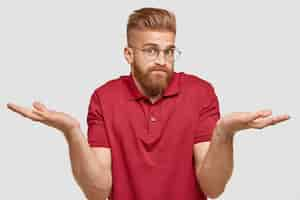 Free photo i know nothing. handsome stylish hipster with thick ginger beard, spreads palms with questionned expression