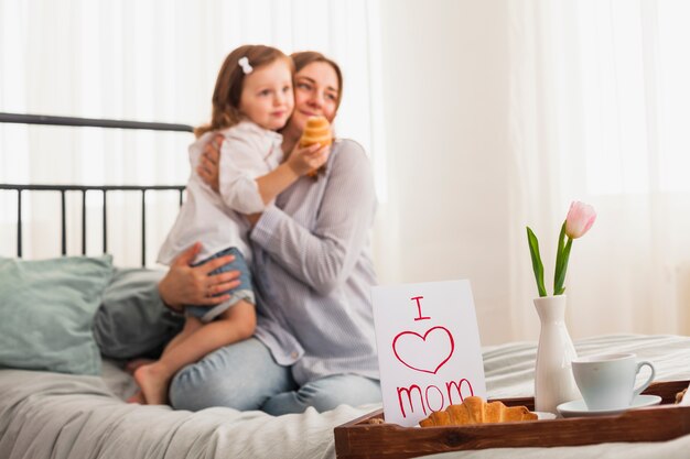 I love mom inscription near hugging mother and daughter 