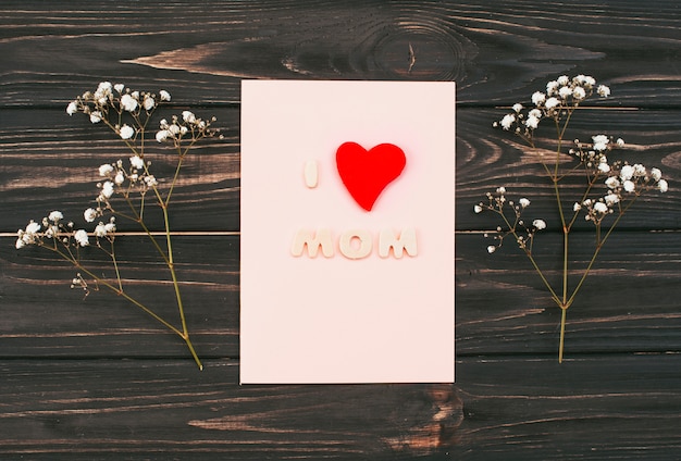 Free Photo i love mom inscription on paper with flower branches 