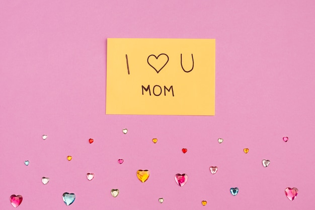 I love u mom title on paper near decorative hearts