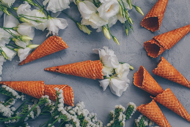 Free Photo ice cream cones with flowers top view on white gray