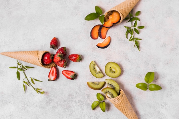 Free Photo ice cream cones with fruits on table