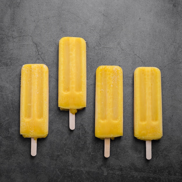 Free photo ice cream on sticks alligned on table