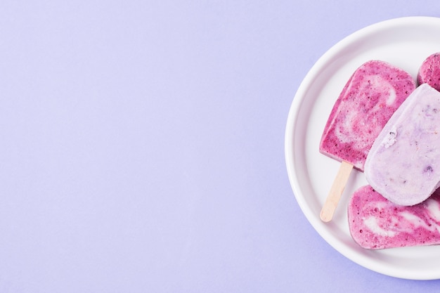 Free photo ice cream sticks on plate with copy-space