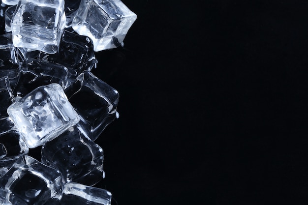 Ice cubes on black surface with copyspace