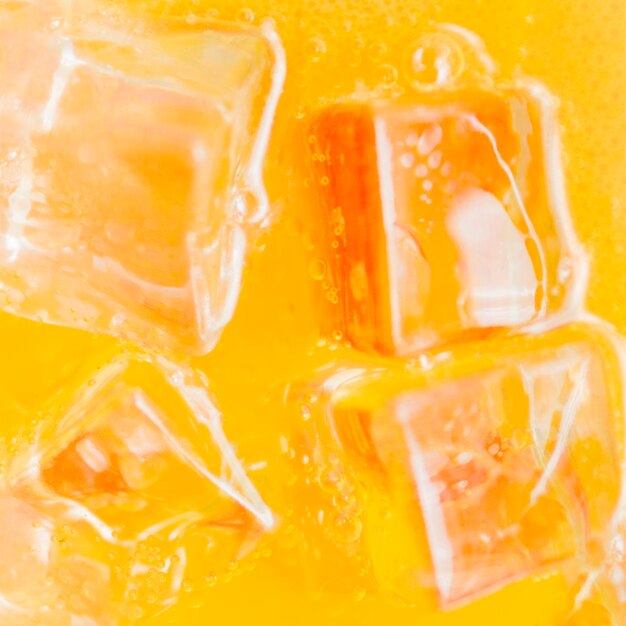 Ice cubes in orange liquid