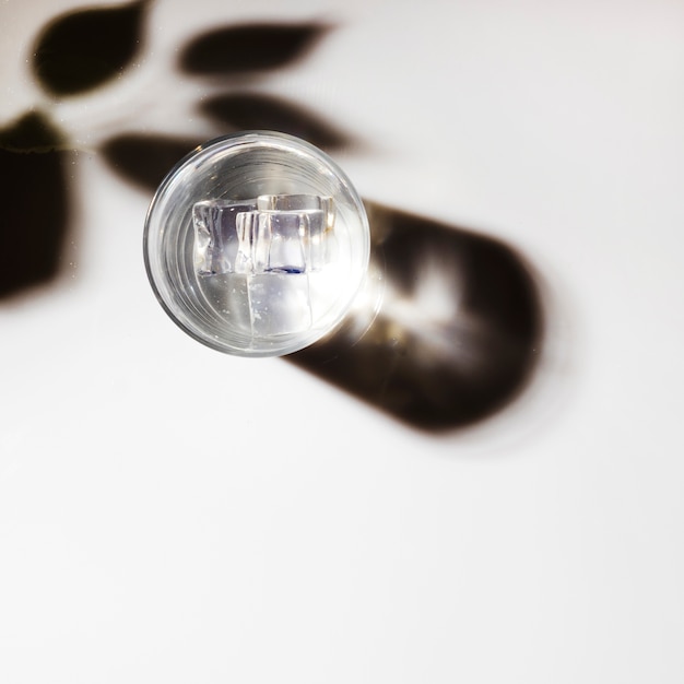 Free Photo ice cubes in transparent glass with shadow on white background