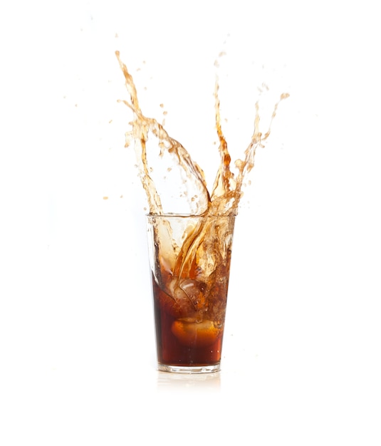 Free photo ice falling into a glass with brown drink