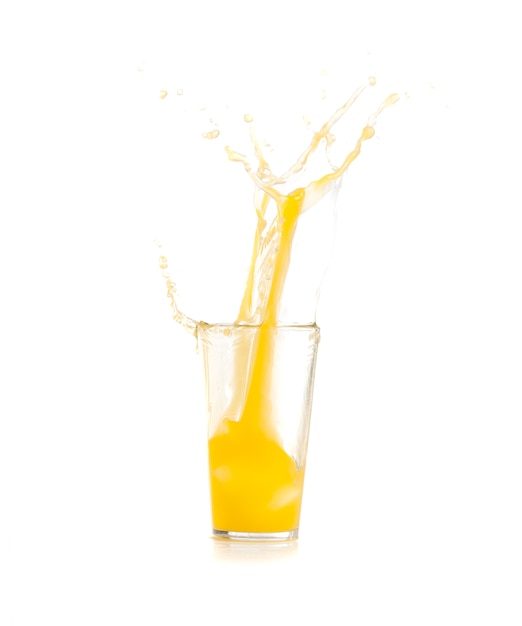 Free photo ice falling into a glass with yellow drink