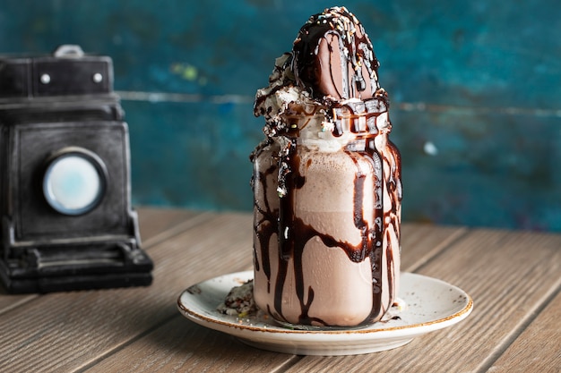 Icecream dessert with bitter chocolate sauce in a white saucer