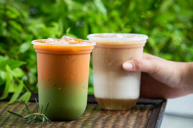 Iced Thai tea mixed with green tea on wooden surface