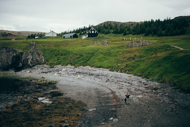 Free Photo icelandic beach scenery, man walks in sweater