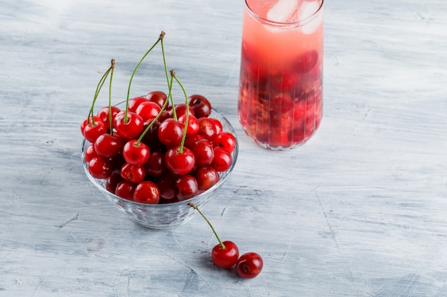 Free photo icy cherry drink in a jug with cherries high