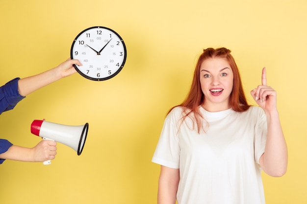 Free photo an idea. caucasian young woman's portrait on yellow studio background, too much tasks. how to manage time right. concept of office working, business, finance, freelance, self management, planning.