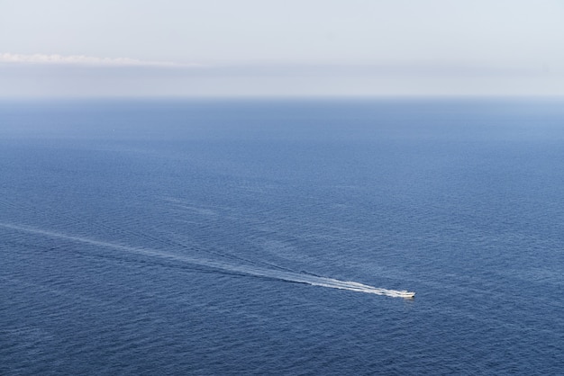 Free Photo idyllic view of a boat in a blue ocean with a clear skyline - perfect for wallpaper